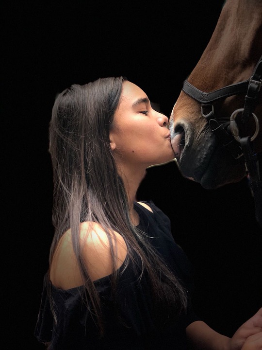 Reiterin küsst Pferd